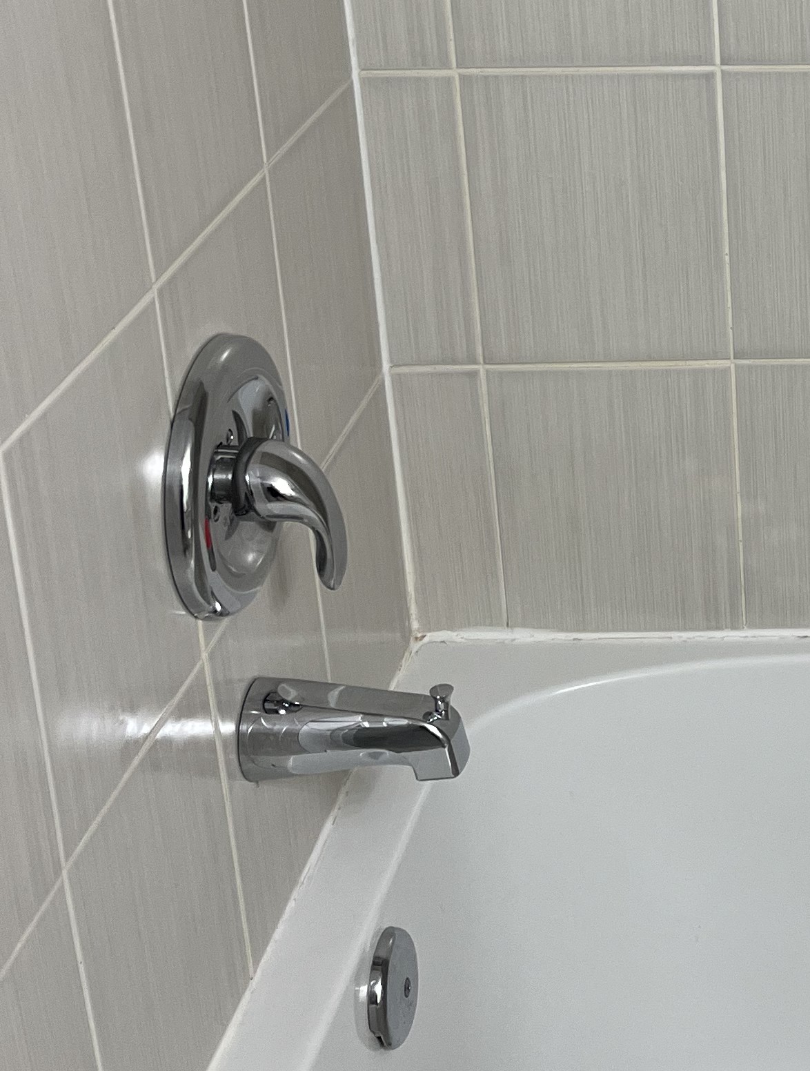 Clean tub, shower surround, and fixtures after bathroom detail cleaning.