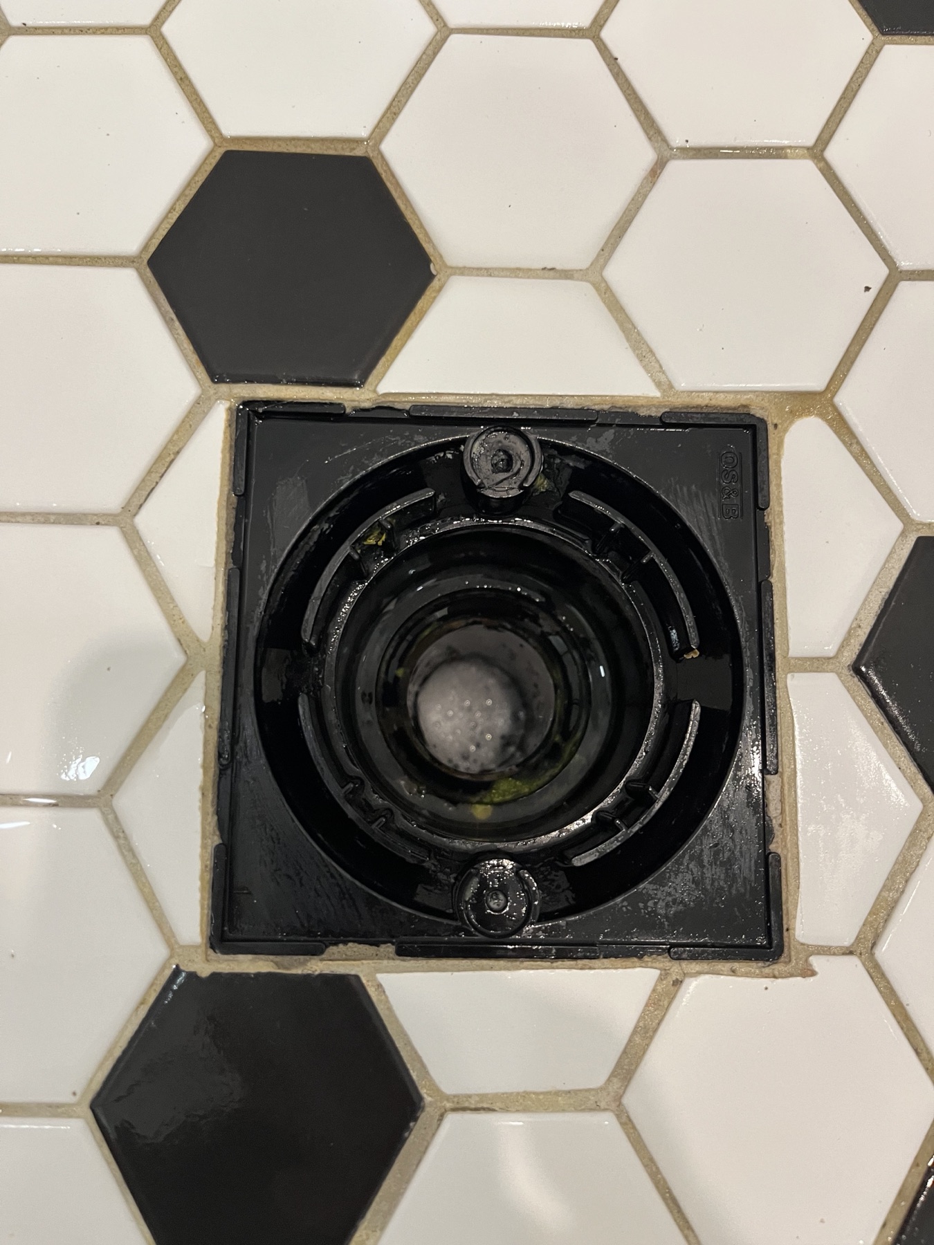 Clean shower drain and nearby tile after bathroom detail cleaning.